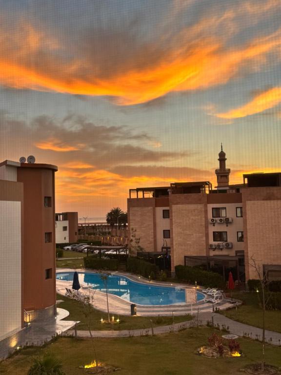 a view of a swimming pool at sunset at Helnan portfouad chalet in Chantier Island