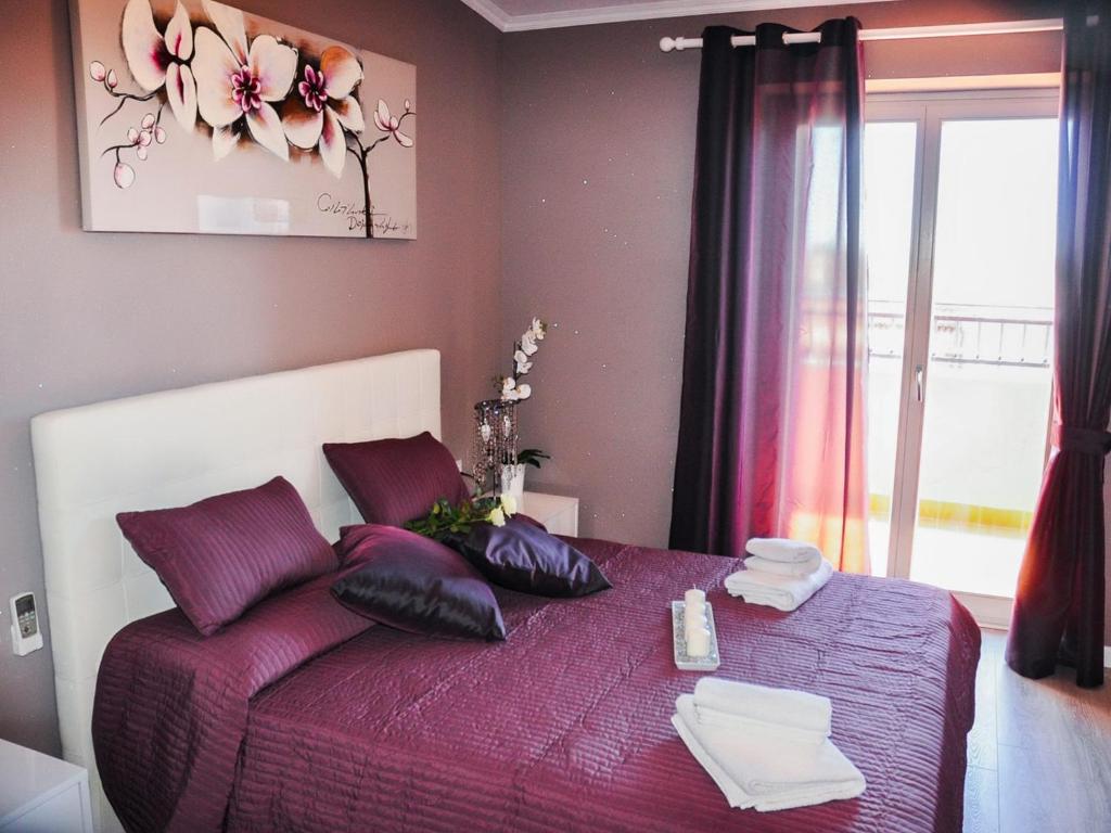 Un dormitorio con una cama morada con almohadas y una ventana en Villa Erasi, en Fiumicino