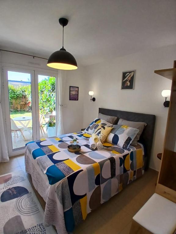 a bedroom with a bed with a colorful blanket at L'Escale Orléans Chambres d'hôtes in Orléans