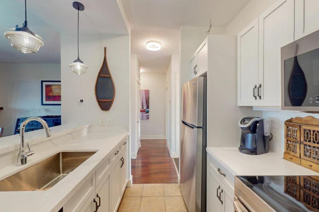 a kitchen with white cabinets and a stainless steel refrigerator at Rivergrass by Property Valet in Blue Mountains