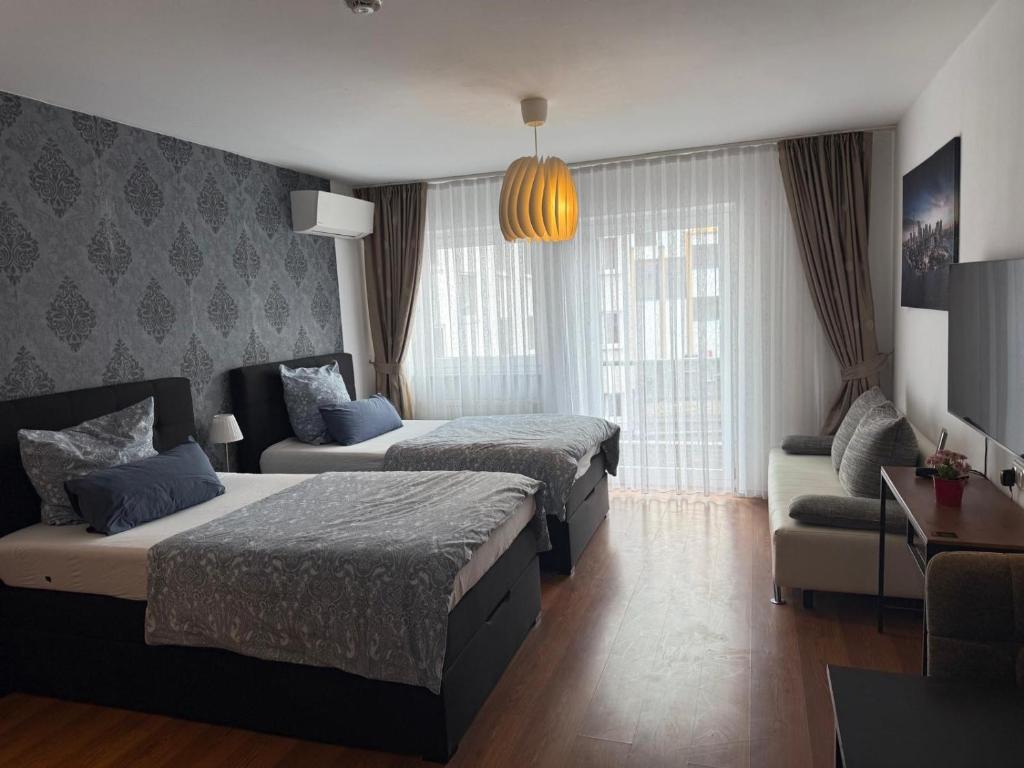 a hotel room with two beds and a couch at Maxim City Apartment in Mainz