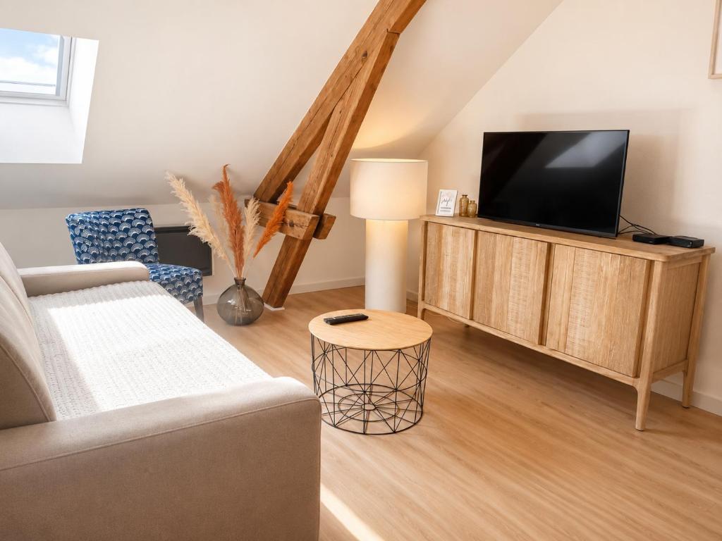 a living room with a couch and a flat screen tv at Bel appartement 2 chambres in Ham