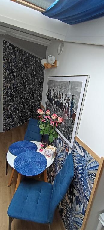 a dining room with a table and blue chairs at Royal EvitaBocelli Spodek by walk self check - in in Katowice