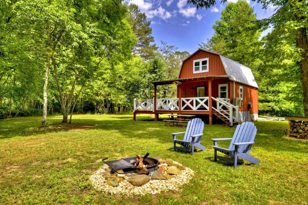 a red barn with two chairs and a fire pit in front of it at Ocoee Cottage Water Front in Copperhill