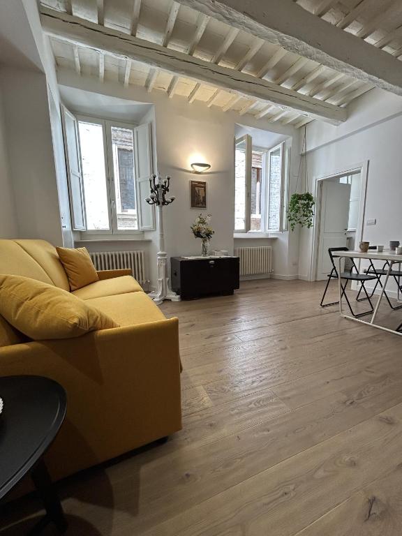 a living room with a yellow couch and a table at Ver Sacrum - Appartamento in centro in Ascoli Piceno