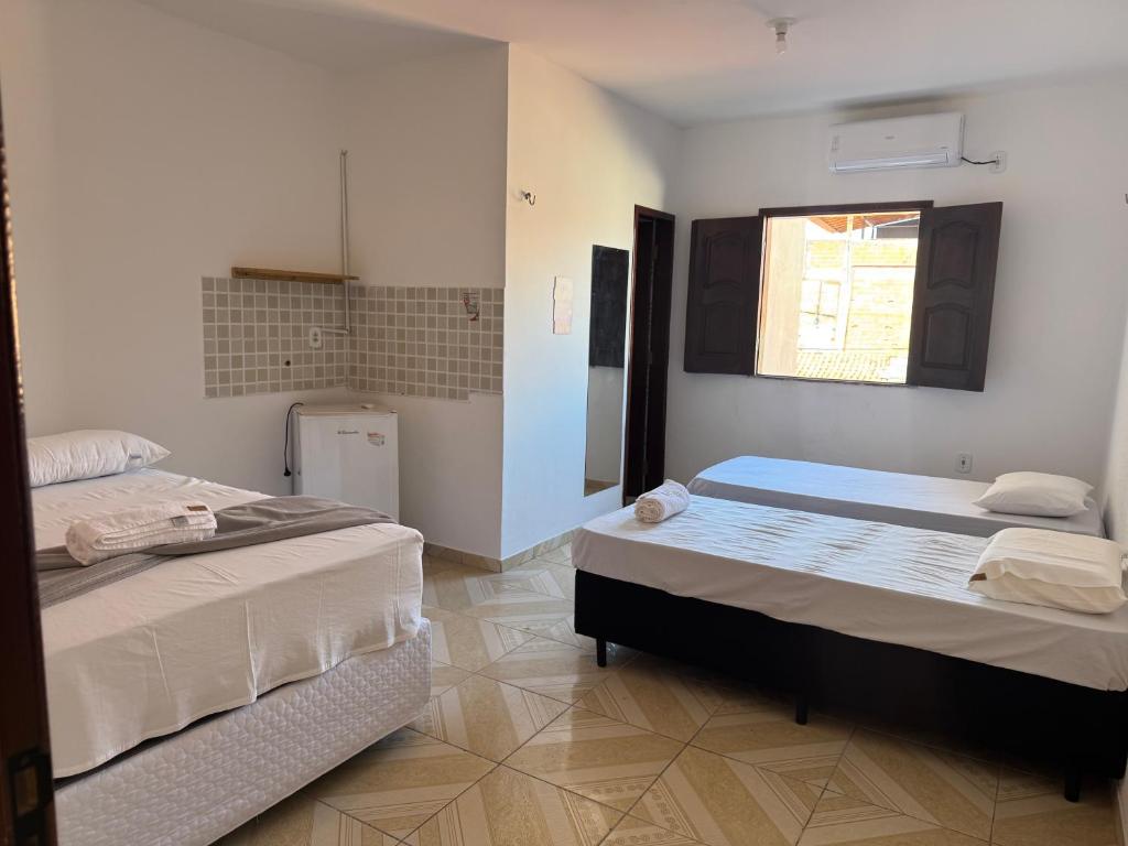 a room with two beds and a window at Hotel Ipê Centro in Barreirinhas