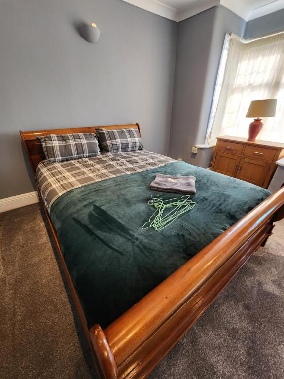 a bedroom with a bed with a green comforter at The Iris in Grays Thurrock