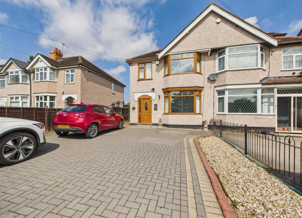 a red car parked in front of a house at Self contained Coventry in Coventry