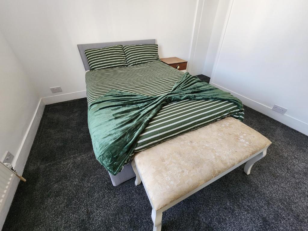 a small bedroom with a bed and a bench at The Moonflower in Grays Thurrock