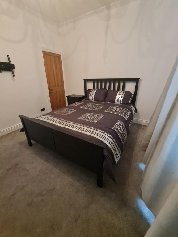 a bedroom with a bed with a brown comforter at The Carnation in Grays Thurrock