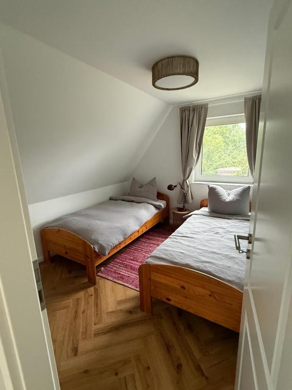 two beds in a small room with a window at Wiesenhuus in Sankt Peter-Ording