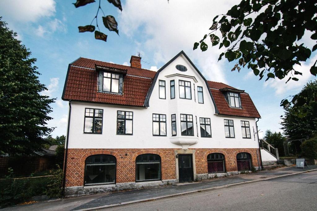 een wit huis met een rood dak bij Urshult Hotell in Urshult