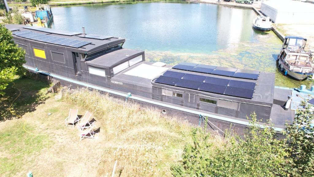 ein Zug mit Solarpaneelen auf einem Fluss in der Unterkunft Woonboot Adonia in Turnhout