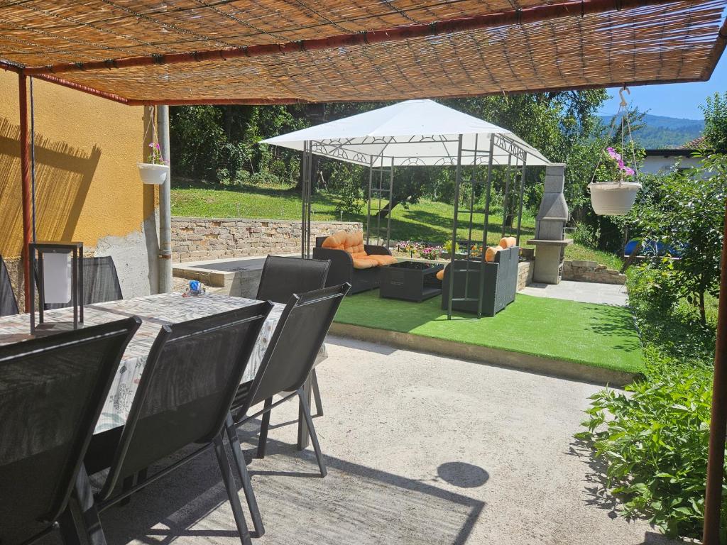 a patio with a table and a couch and an umbrella at Kovaci Garden House in Sarajevo