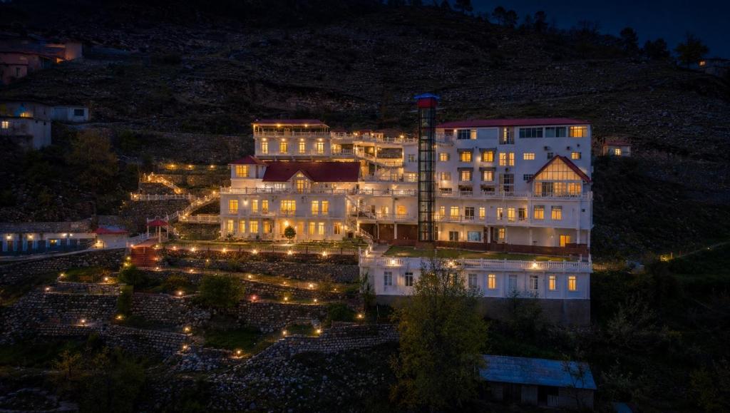 a large building with lights in front of it at night at Grand Montis Hotel in Abbottabad