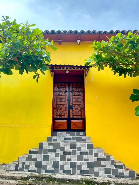 a yellow house with stairs leading to a door at Estadia colonial in Suchitoto
