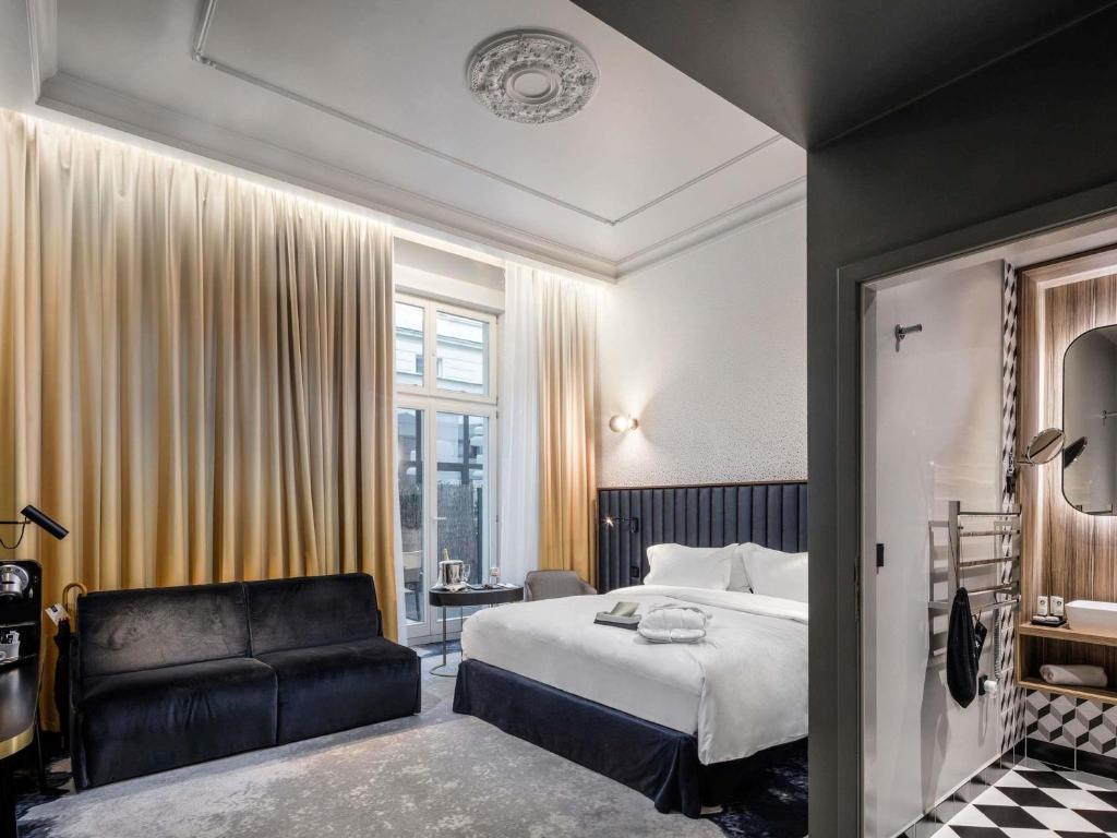 a hotel room with a bed and a chair at Century Old Town Prague - MGallery Collection in Prague