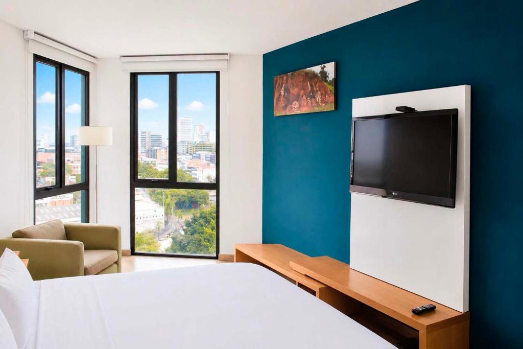 a hotel room with a bed and a flat screen tv at Alko Select in Cali