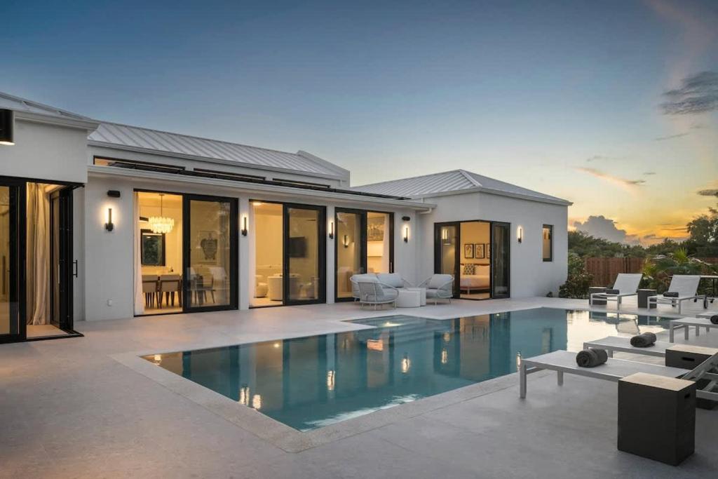 a house with a swimming pool in front of a house at Villa Seadream - Upper East Side Enclave #16 in Long Bay Hills