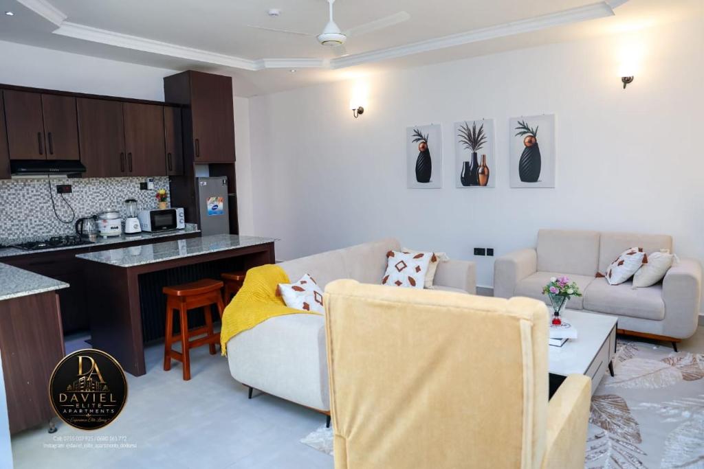 a living room with a couch and a kitchen at Daviel Elite Apartments in Dodoma
