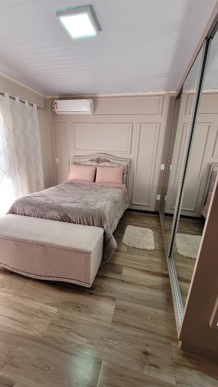 a bedroom with a bed with pink pillows at Próximo aSerra do Rio do Rastro in Lauro Müller