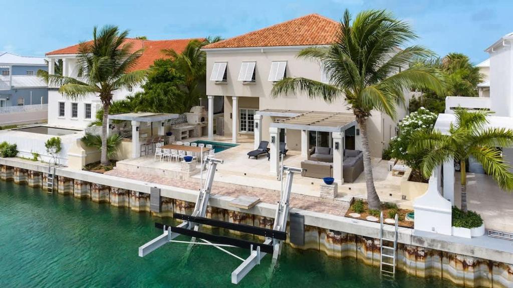 a house on the water with a dock at Abundance and Prosperity Villa in Long Bay Hills