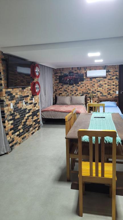 a room with a table and chairs and a bed at Garagem 36 próximo a Serra do Rio do Rastro in Lauro Müller
