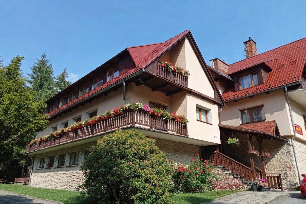 ein Gebäude mit Blumen auf den Balkonen in der Unterkunft AGAT Karpacz in Karpacz