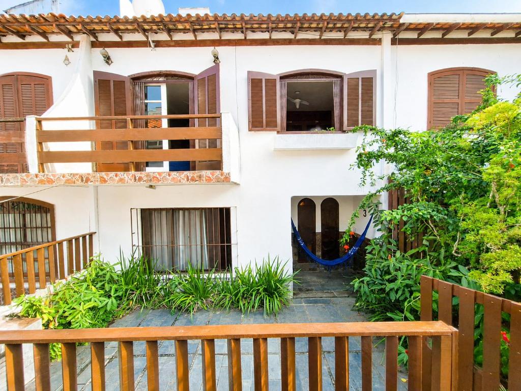 a house with windows and a wooden fence at Casa da Prainha - a 3min da areia - aproveite até o pôr do sol! in Arraial do Cabo