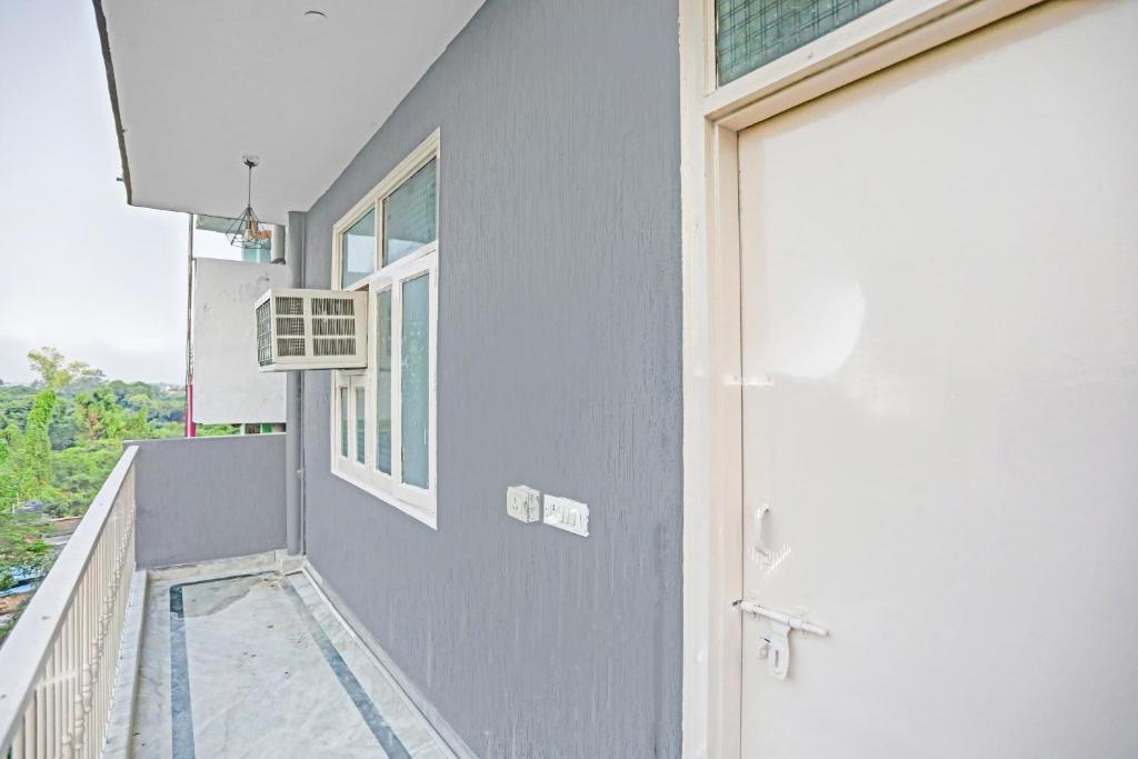 a house with a balcony with a door at Hotel O The Premium Villa in New Delhi