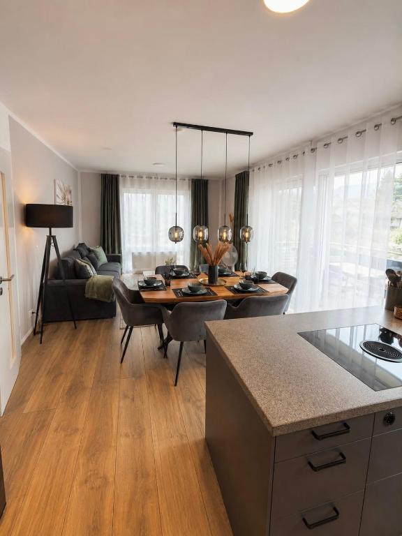 a kitchen and living room with a table and a couch at Harmony Hideaways I 90qm I Bergblick I 3 Balkone I seenah in Prien am Chiemsee