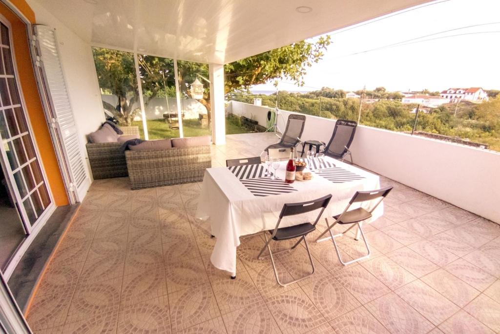 a white table and chairs on a balcony at Oasis Rest in Porto Martins