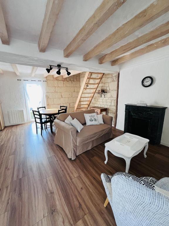 a living room with a couch and a table at Le Clos de Tuffeau in Turquant
