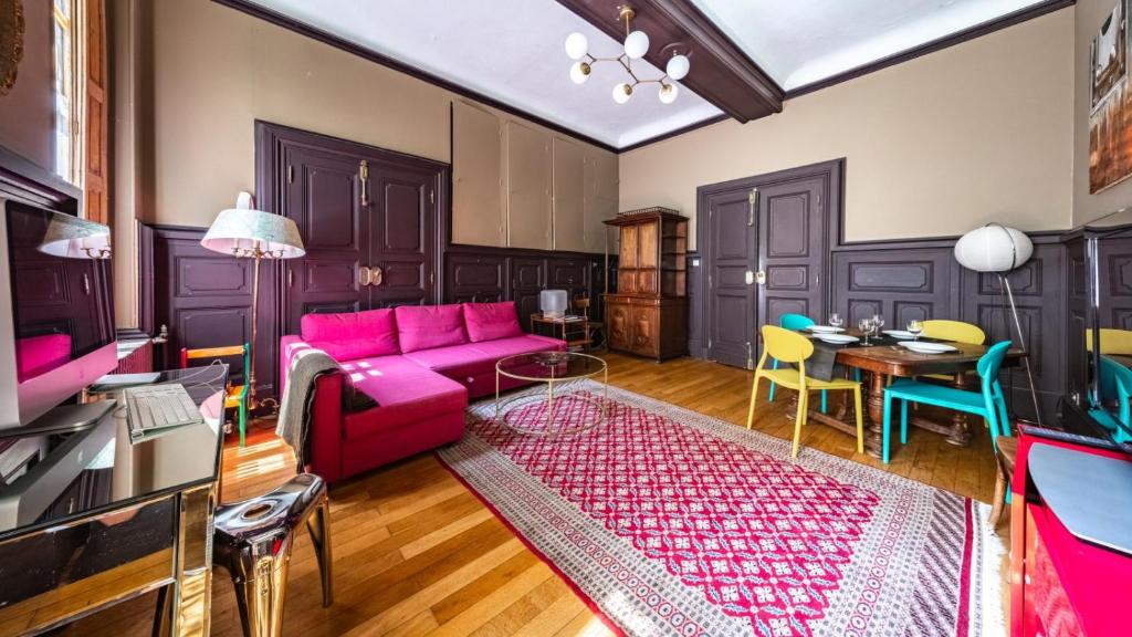 a living room with a pink couch and a table at Authentic Flat in Dijon in Dijon