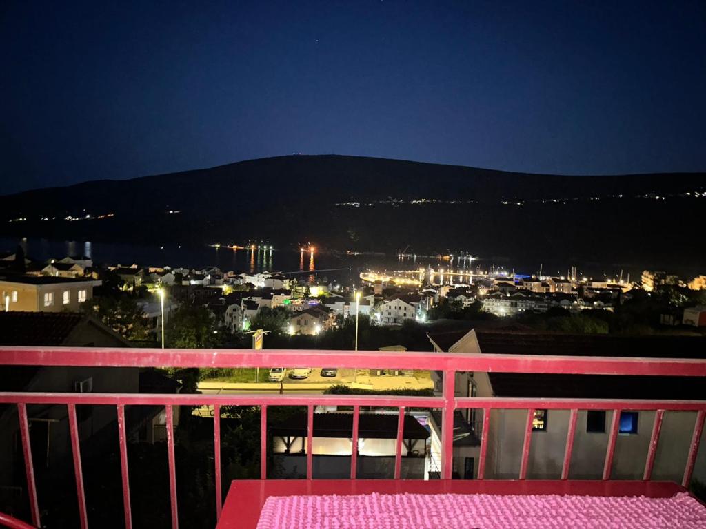 a pink bench sitting on top of a balcony at night at Đenovici Apartmans in Đenovići
