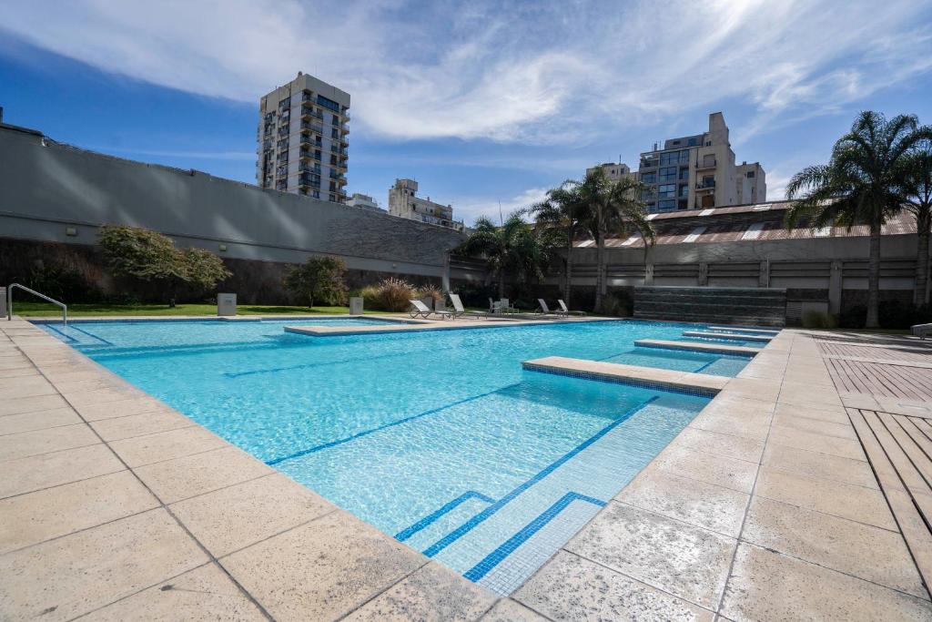 a large swimming pool with blue water in a building at San Telmo Spa in Buenos Aires