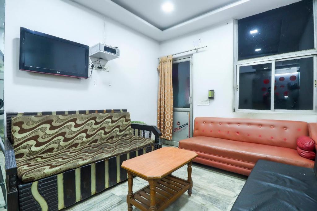 a living room with a couch and a tv at Hotel O Bright in Jamshedpur