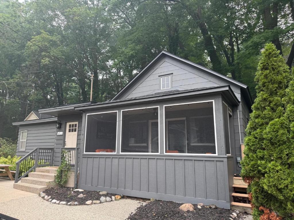 ein graues Minihaus mit einem großen Fenster in der Unterkunft Screened porch pt water views hot tub walk to Saug in Saugatuck