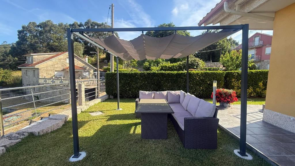 a purple couch and a table under a canopy at Casa Eira de Arriba - by entreRías in Cangas de Morrazo