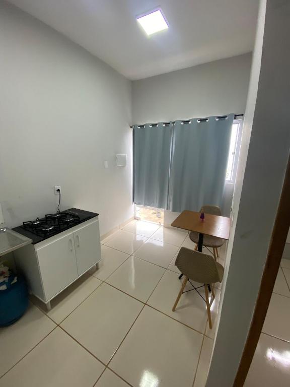 a white kitchen with a stove and a chair in it at Aconchegante é silencioso in Rio Verde