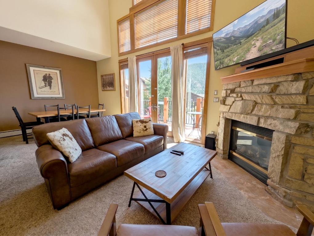 a living room with a couch and a fireplace at Antlers Gulch 303 by SummitCove Lodging in Colorado in Keystone