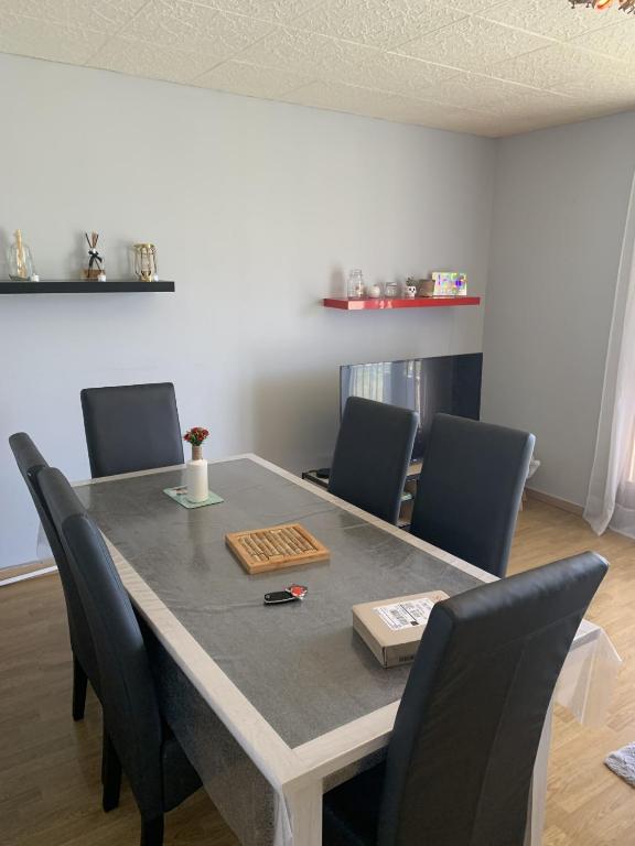 a dining room table with chairs and a table at Le Jocondien in Joué-lès-Tours