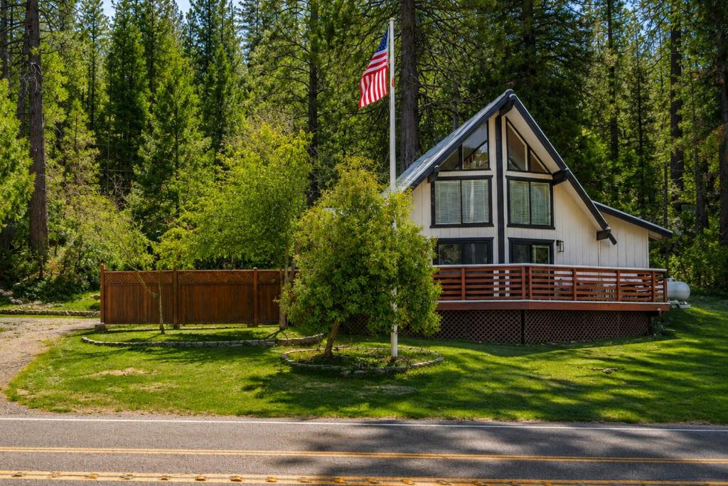 a house with an american flag on top of it at Serene Cabin Retreat Between Murphys & Arnold in Murphys