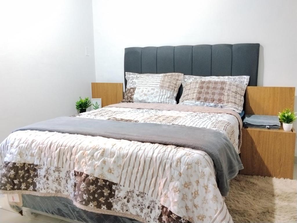 a bedroom with a large bed with a wooden headboard at Colman Apart Central 07 in Ciudad del Este