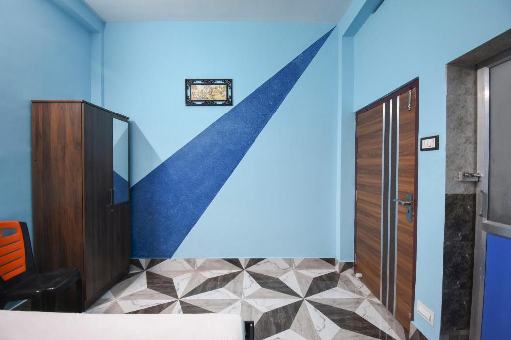 a room with a blue wall with a checkered floor at Hotel O Aagman Guest House in Hākala