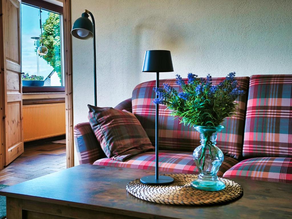 a vase of flowers on a table in a living room at Ferienwohnung Dreamy Daisy in Morbach