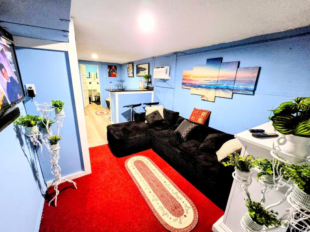 a living room with a black couch and a red carpet at 2 BEDROOM APARTMENT 20 min-Newark Airport 15 min- Stadium Downtown Newark- Branch Brook park inn in Newark
