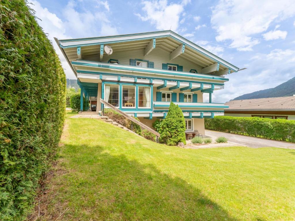a large blue house with a lawn in front of it at Tauernpanorama in Krimml