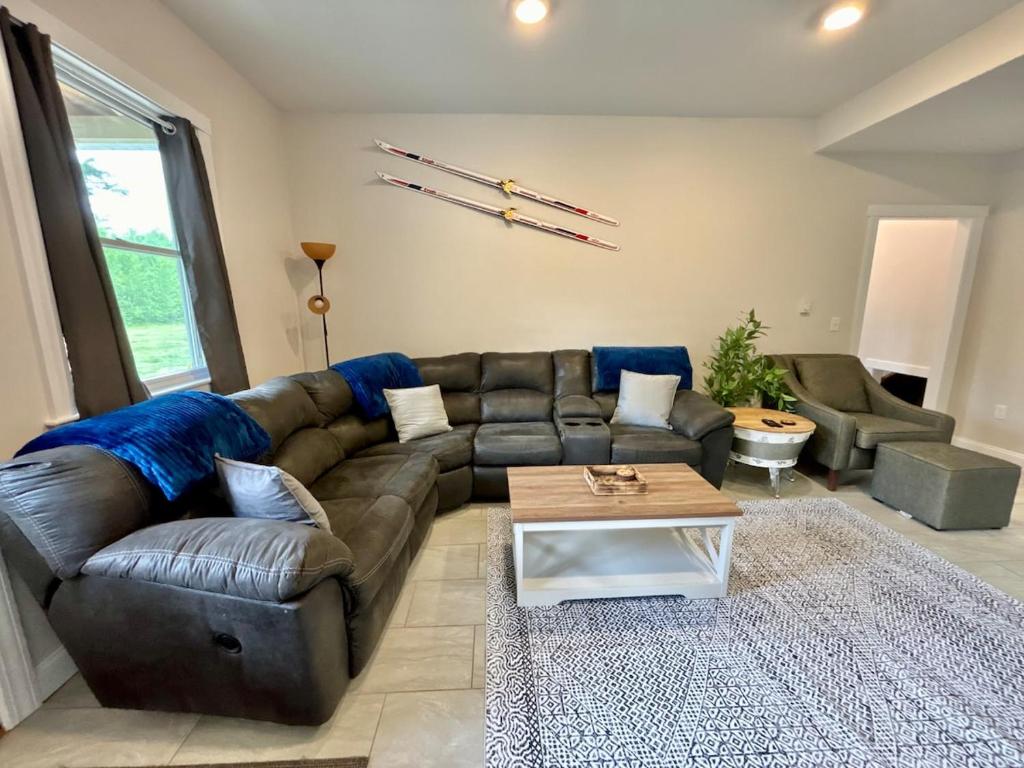 a living room with a leather couch and a coffee table at The Happy Hive in Bridgton