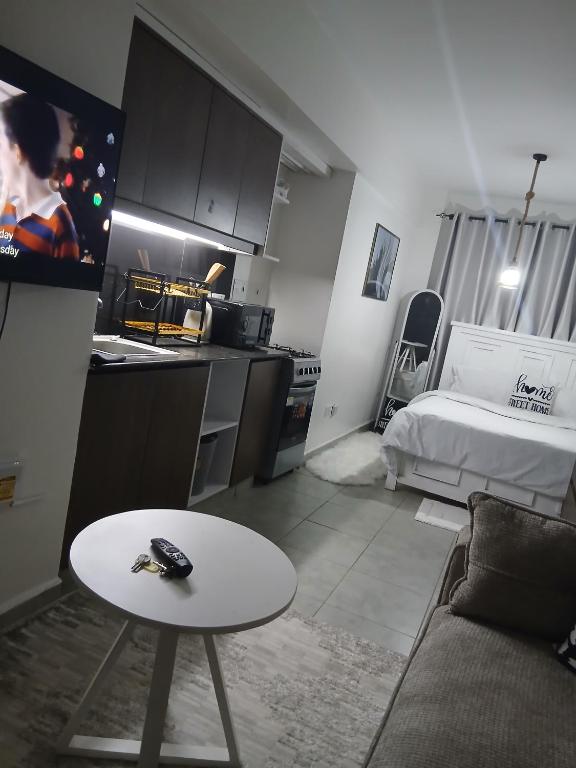 a living room with a couch and a table and a bed at Luna Homes at Tsavo Sunset, Kiambu Road in Kiambu